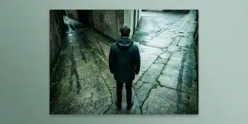 A person stands at a diverging fork in a cracked, rain-slicked concrete path, contemplating two uncertain routes, symbolizing complex decisions in benefits uptake.