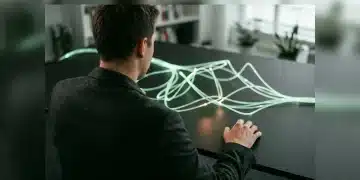 A person observing an intricate, glowing green fiber optic network spreading across a minimalist table, symbolizing the evolution of integrated, holistic employee benefits.